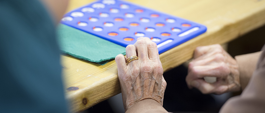 En äldre persons händer och ett spel